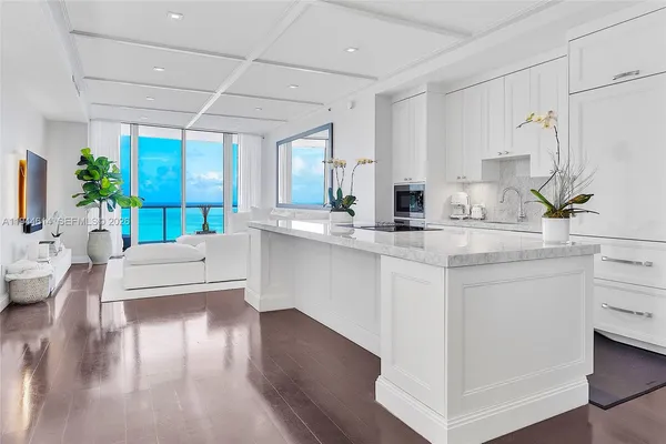 a kitchen with kitchen island granite countertop a sink cabinets and wooden floor