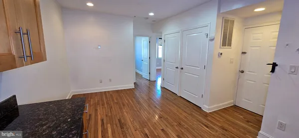 a view of empty room with wooden floor