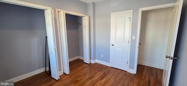an empty room with wooden floor and closet