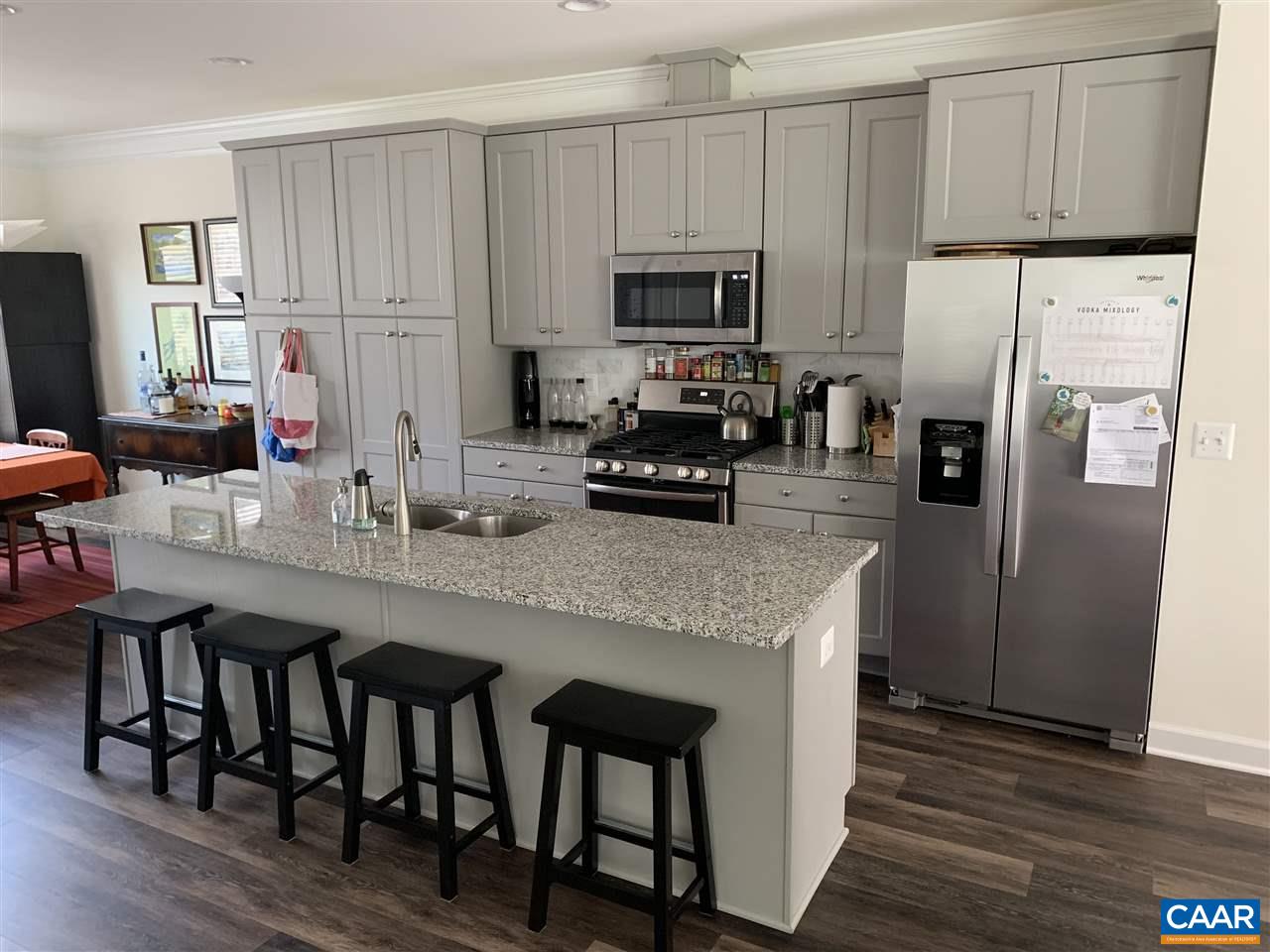 143 Junction Lane Charlottesville, VA 22902 - Photo 5 of 16 a kitchen with stainless steel appliances granite countertop a table chairs refrigerator and microwave