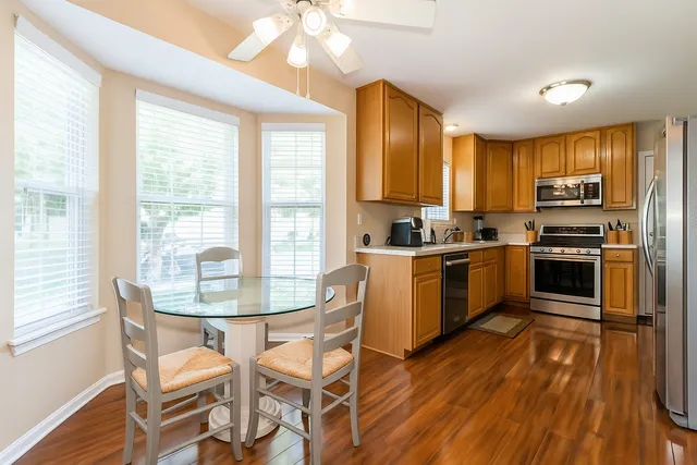 a kitchen with a table chairs microwave and cabinets