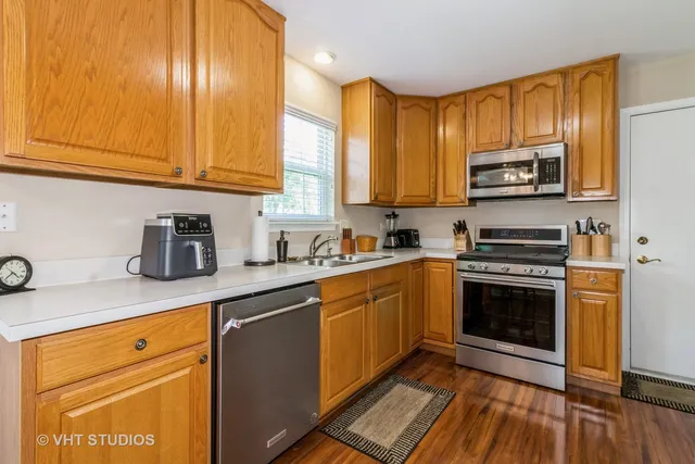 a kitchen with stainless steel appliances granite countertop a stove a sink and a microwave