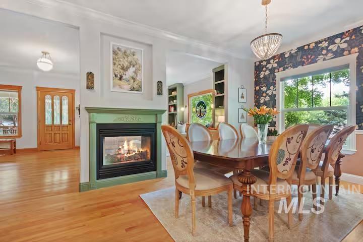 1617 North 5th Street Boise, ID 83702 - Photo 10 of 36 Dining room featuring wood finished floors, a multi sided fireplace, and a chandelier