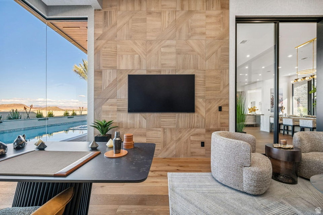 2867 East Granite Way St. George, UT 84790 - Photo 22 of 69 Floor-to-ceiling glass wall, wood-finish flooring, patterned wood wall paneling, sliding glass door, and a built-in entertainment area