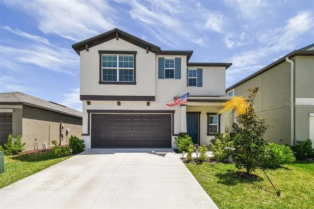 a front view of a house with a yard and garage