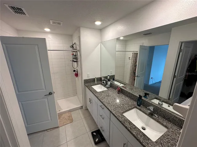 a bathroom with double vanity and a bathtub
