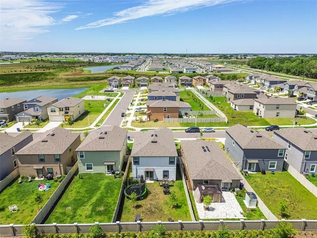 an aerial view of residential houses with outdoor space and ocean view