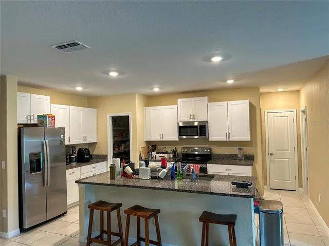 a kitchen with stainless steel appliances a refrigerator sink and microwave