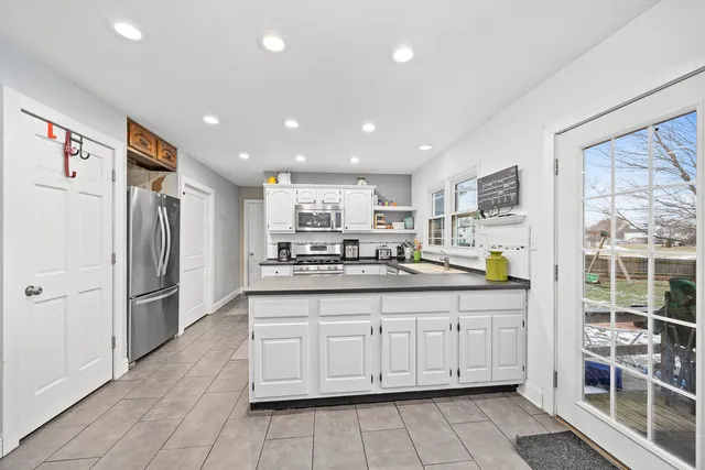 a kitchen with stainless steel appliances granite countertop a refrigerator and a cabinets