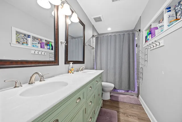a bathroom with a double vanity sink mirror and toilet