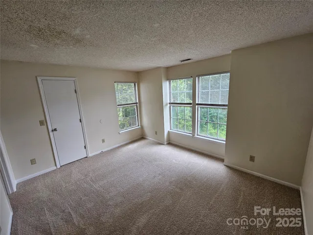 an empty room with windows and closet