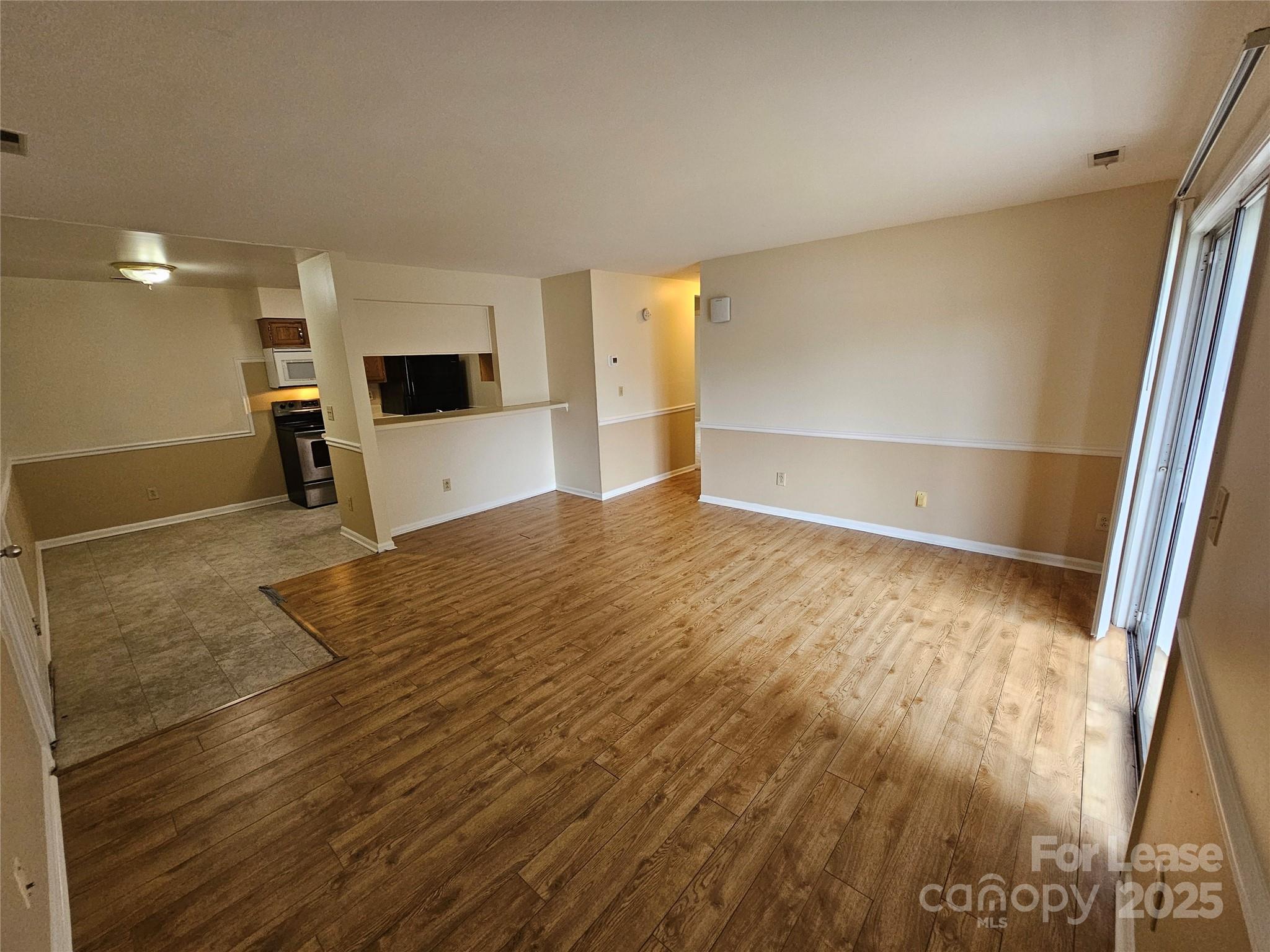 9619 Vinca Circle, Unit B Charlotte, NC 28213 - Photo 5 of 18 a view of a big room with wooden floor and windows