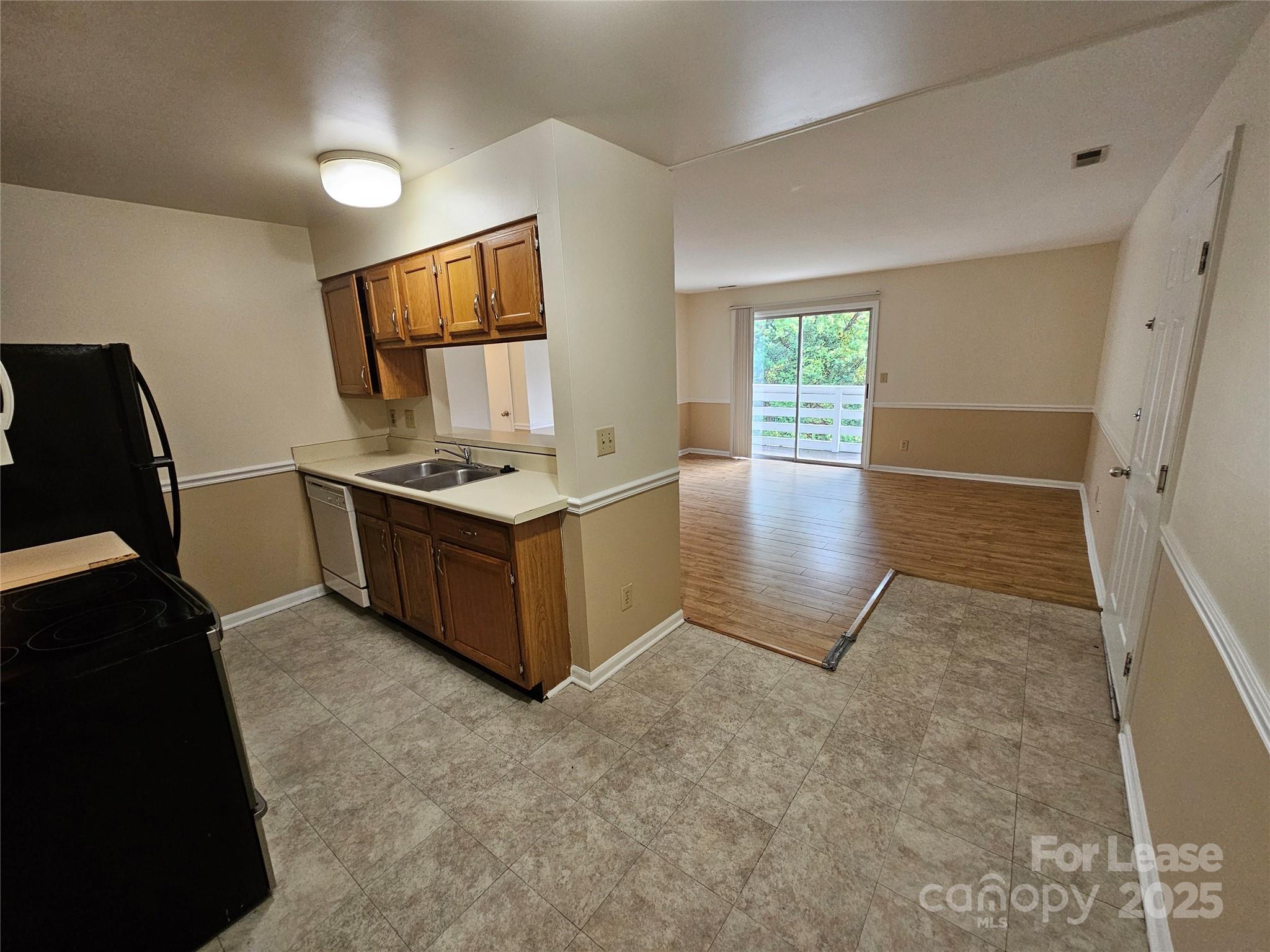 9619 Vinca Circle, Unit B Charlotte, NC 28213 - Photo 6 of 18 a kitchen with stainless steel appliances granite countertop a stove a sink and a refrigerator