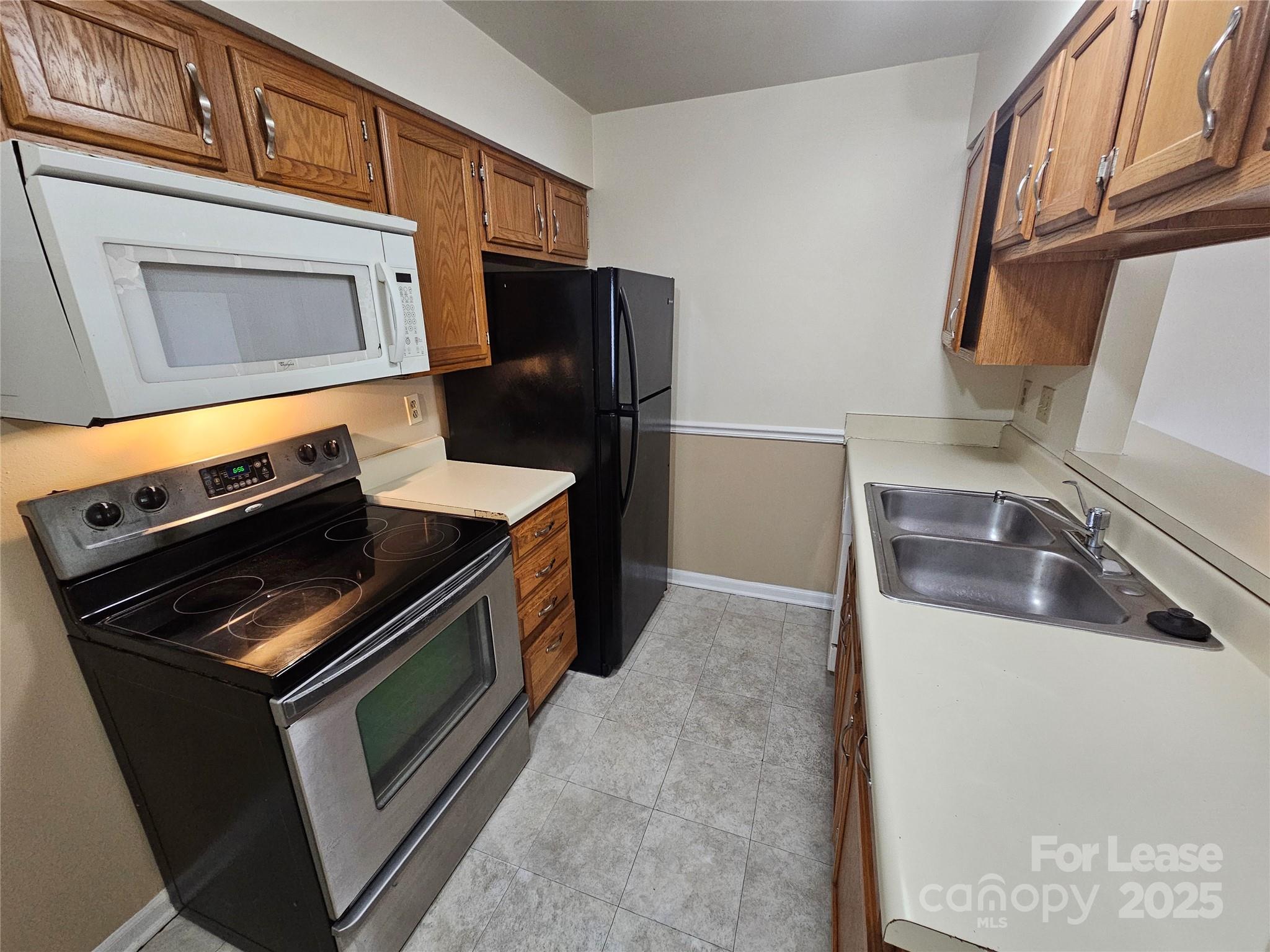 9619 Vinca Circle, Unit B Charlotte, NC 28213 - Photo 7 of 18 a kitchen with stainless steel appliances granite countertop a sink stove and refrigerator