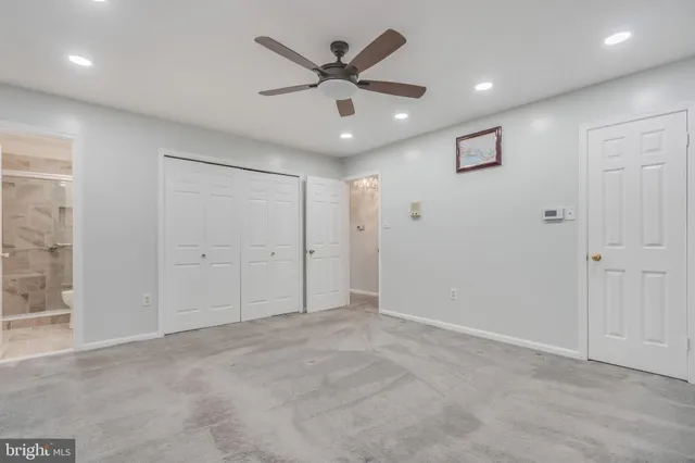 an empty room with closet and ceiling fan