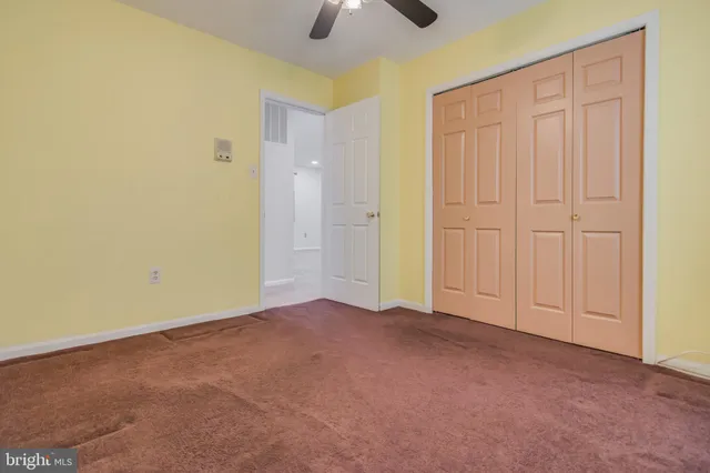 an empty room with chandelier fan