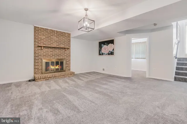 a view of an empty room with a fireplace and a window