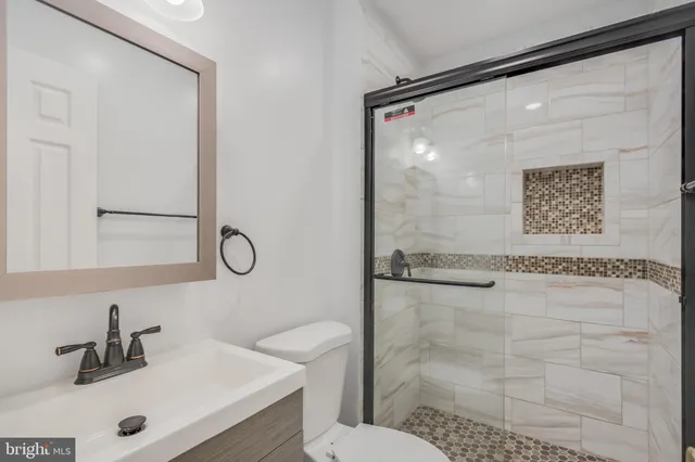 a bathroom with a shower sink and mirror