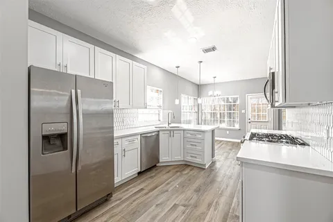 a kitchen with a refrigerator stove and sink