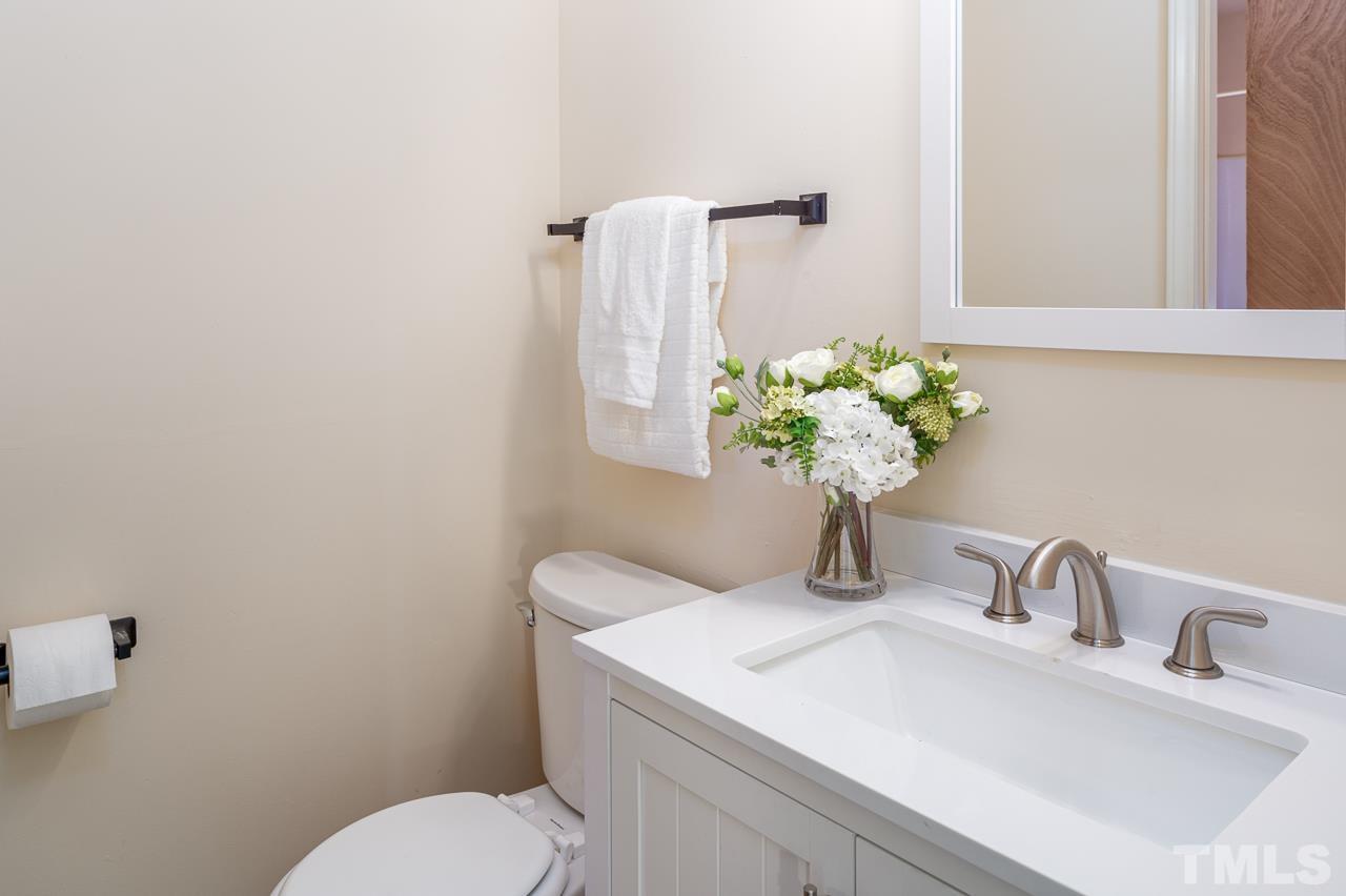4264 Kaplan Drive Raleigh, NC 27606 - Photo 18 of 23 a bathroom with a sink a toilet and a mirror