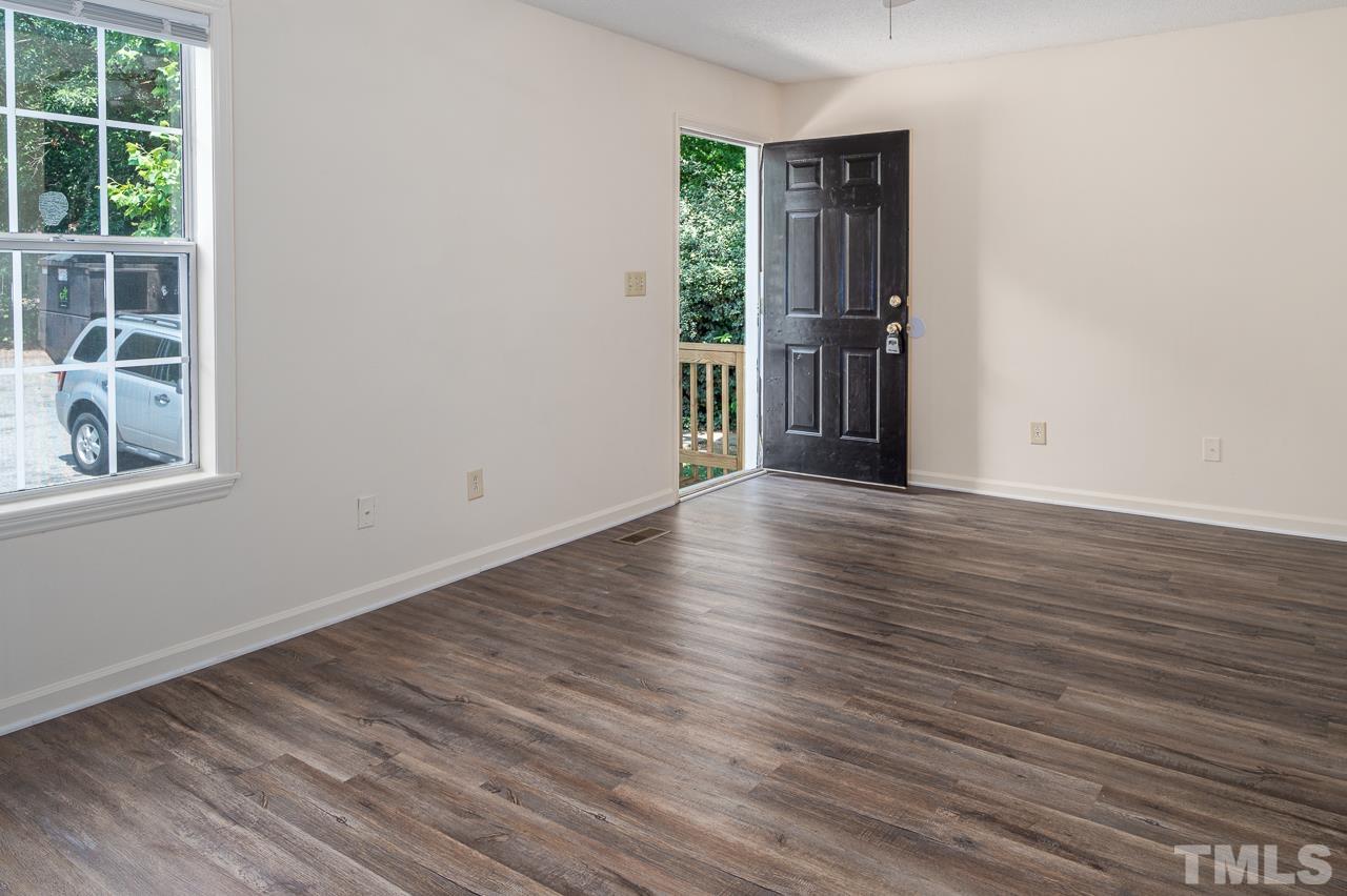 4264 Kaplan Drive Raleigh, NC 27606 - Photo 3 of 23 an empty room with wooden floor and windows