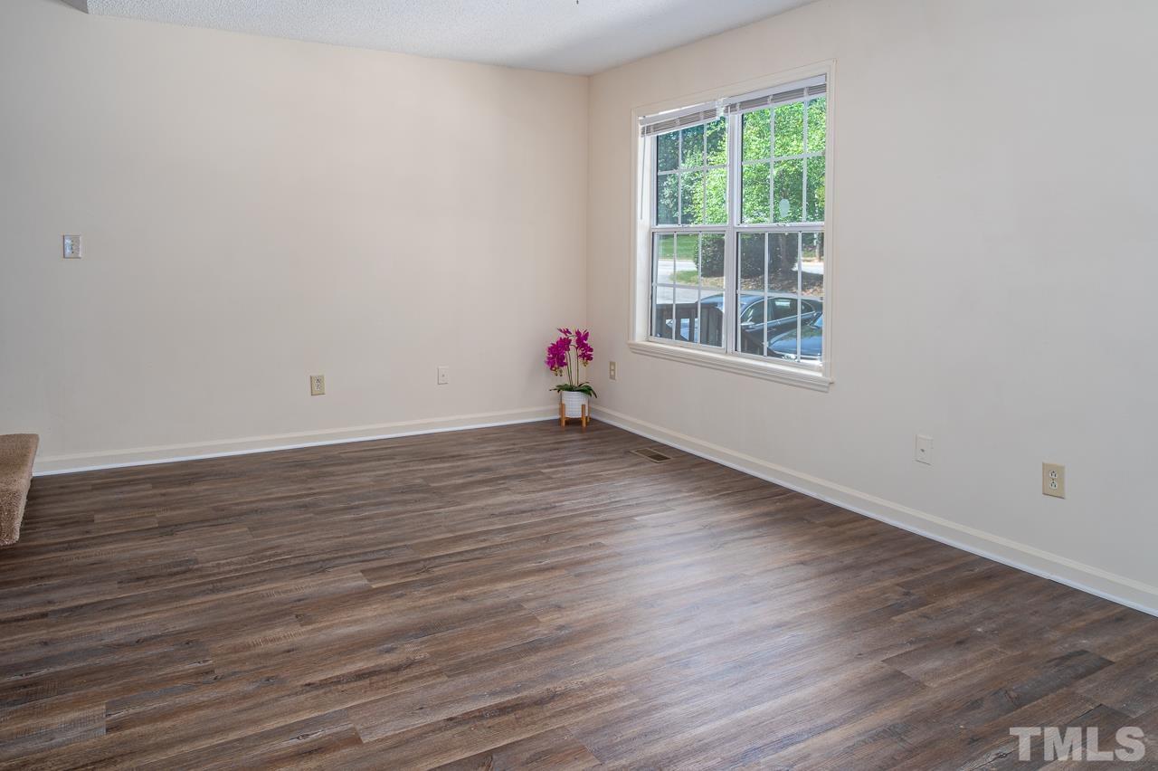 4264 Kaplan Drive Raleigh, NC 27606 - Photo 4 of 23 a view of an empty room with wooden floor and a window