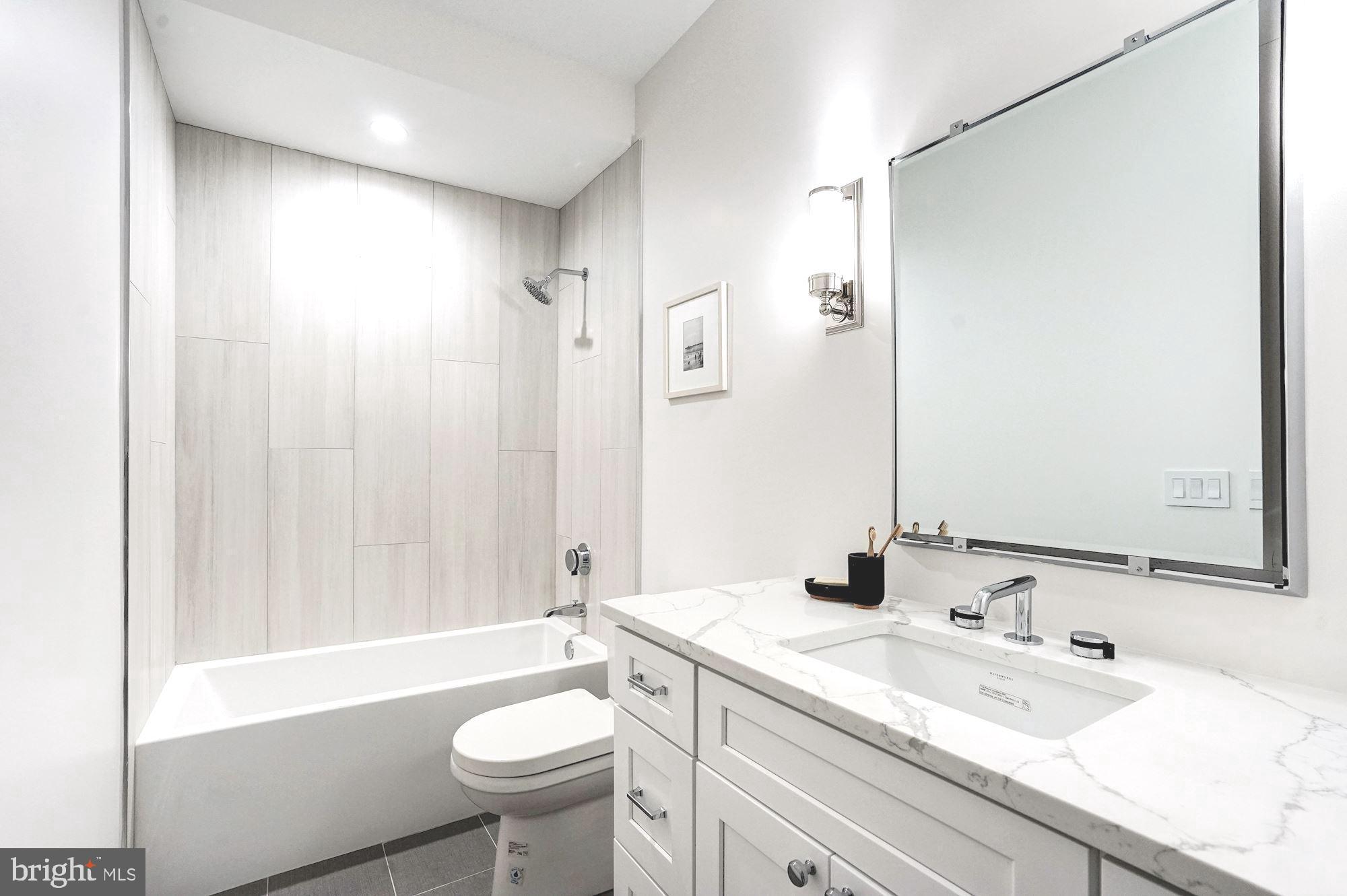 1603 Isherwood Street Northeast, Unit 2 Washington, DC 20002 - Photo 17 of 24 a bathroom with a granite countertop sink toilet and shower