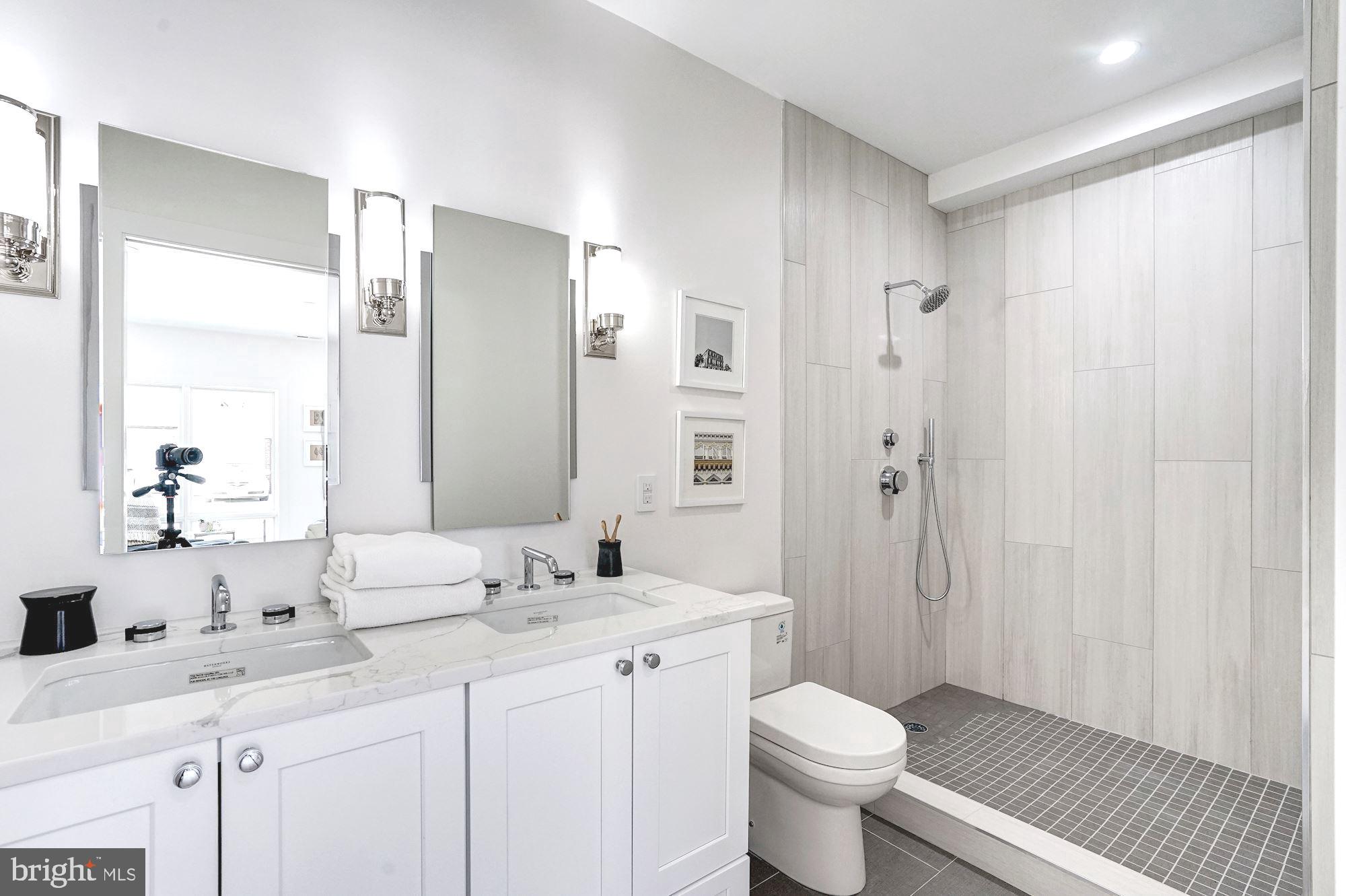 1603 Isherwood Street Northeast, Unit 2 Washington, DC 20002 - Photo 20 of 24 a bathroom with a double vanity sink toilet and shower