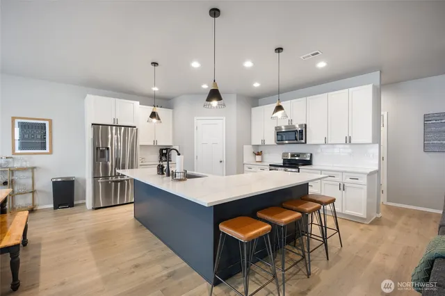 a kitchen with kitchen island a sink stove and refrigerator