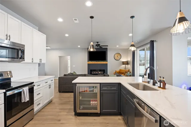 a large kitchen with stainless steel appliances kitchen island granite countertop a sink a stove and a wooden floors