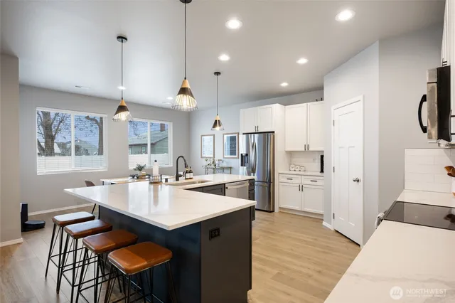 a kitchen with refrigerator and chairs