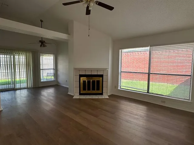 an empty room with floor to ceiling windows and fireplace