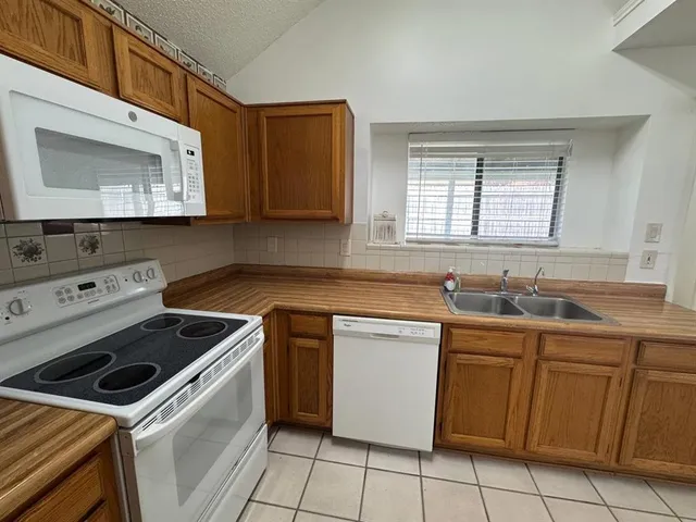 a kitchen with a sink stove top oven and microwave