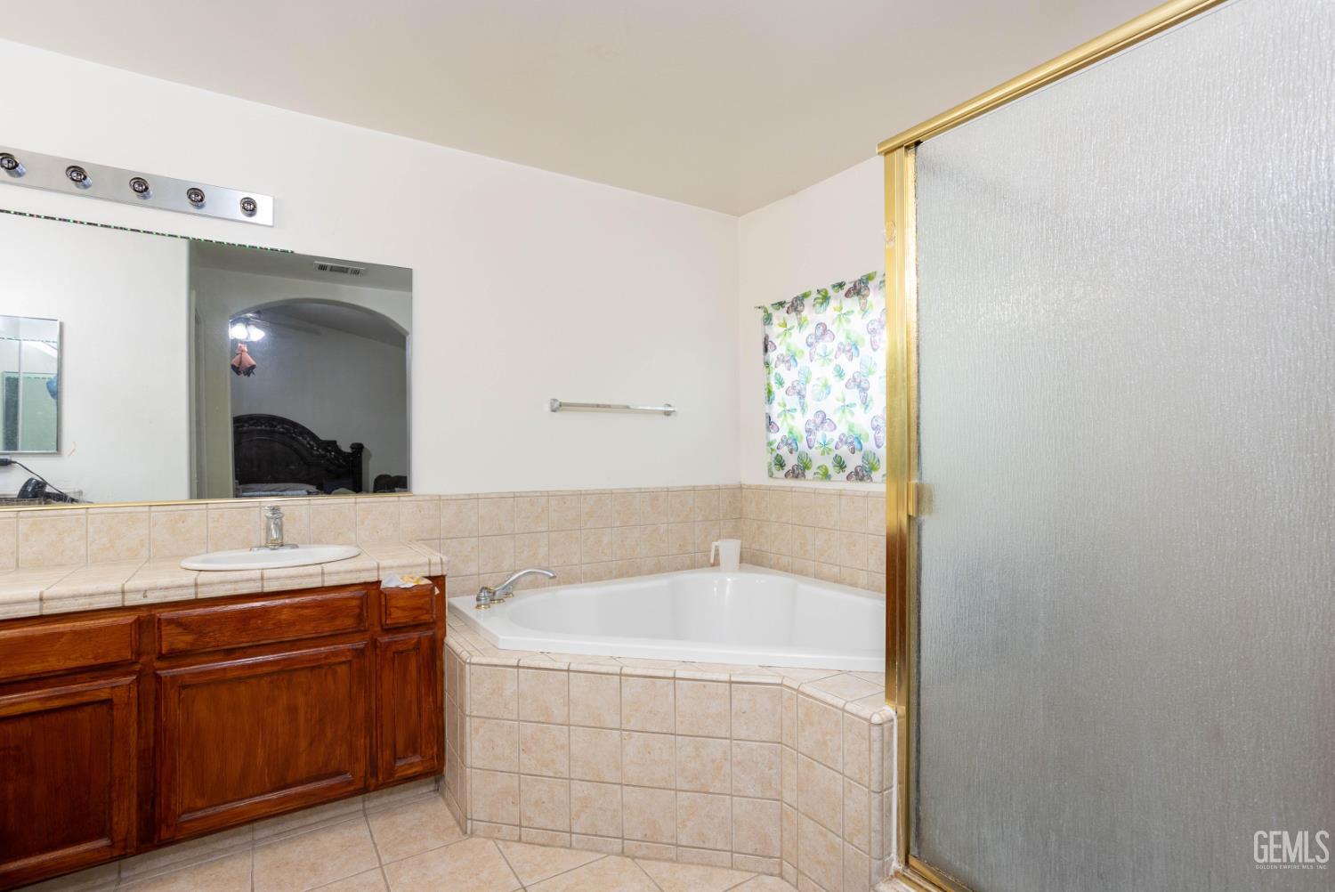 Undisclosed Address Bakersfield, CA 93313 - Photo 11 of 19 a spacious bathroom with a granite countertop sink and a mirror