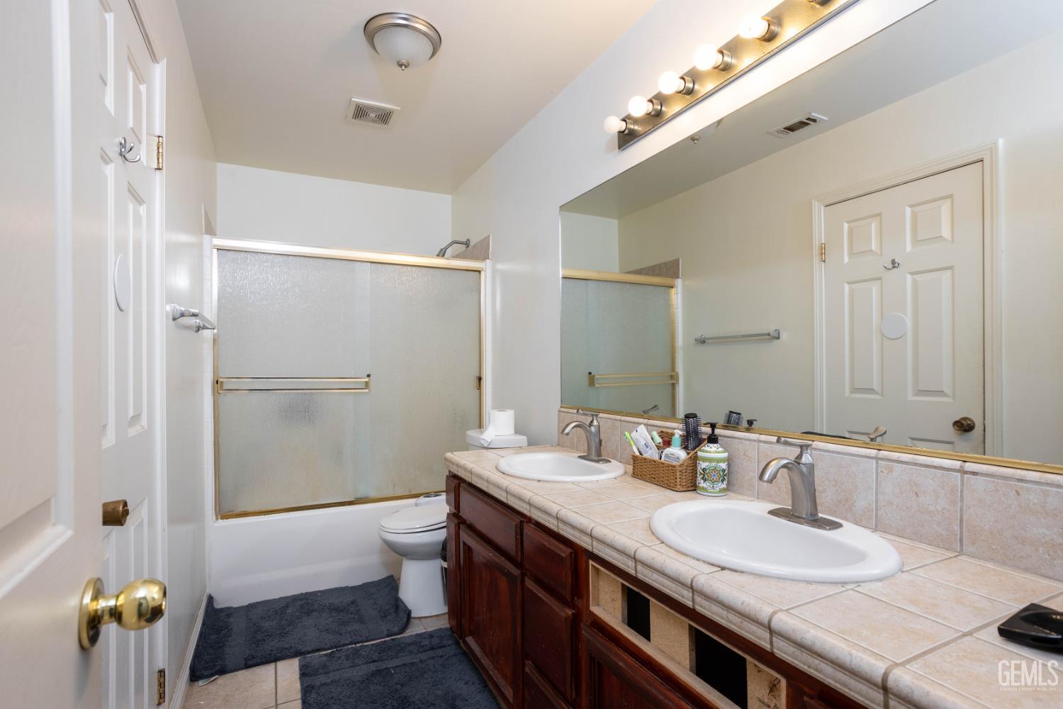 Undisclosed Address Bakersfield, CA 93313 - Photo 12 of 19 a bathroom with a granite countertop sink a toilet a mirror and shower