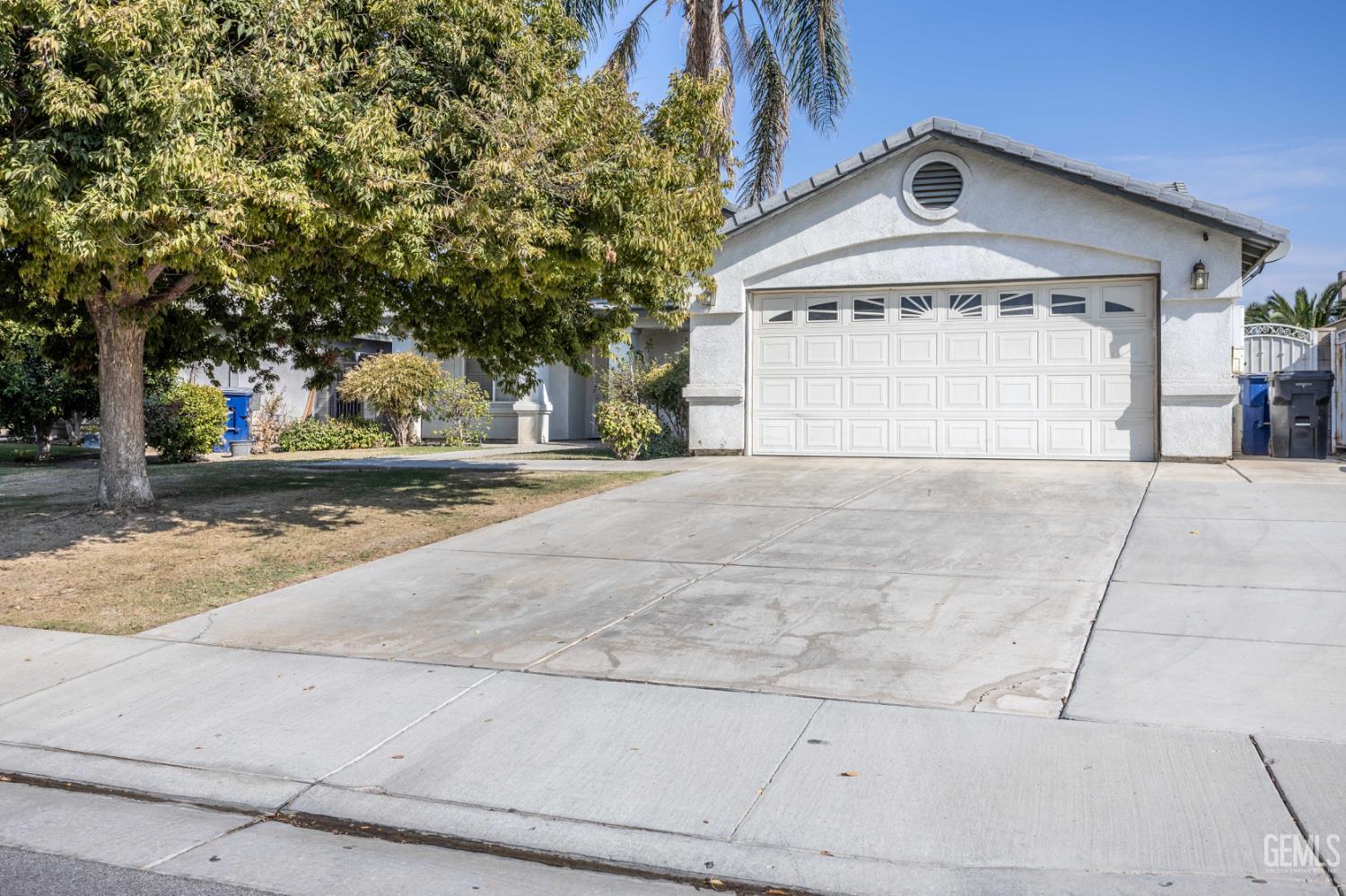 Undisclosed Address Bakersfield, CA 93313 - Photo 2 of 19 a view of a house with a yard and garage
