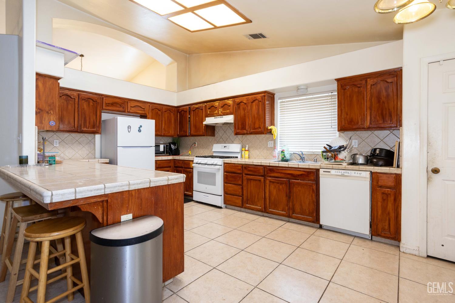 Undisclosed Address Bakersfield, CA 93313 - Photo 7 of 19 a kitchen with stainless steel appliances a stove a sink cabinets and a refrigerator