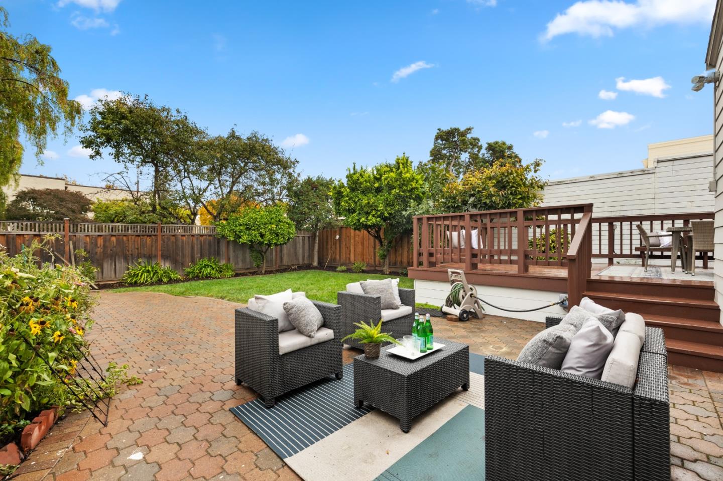220 Channing Road Burlingame, CA 94010 - Photo 55 of 60 a view of a patio with couches chairs and a fire pit with wooden fence