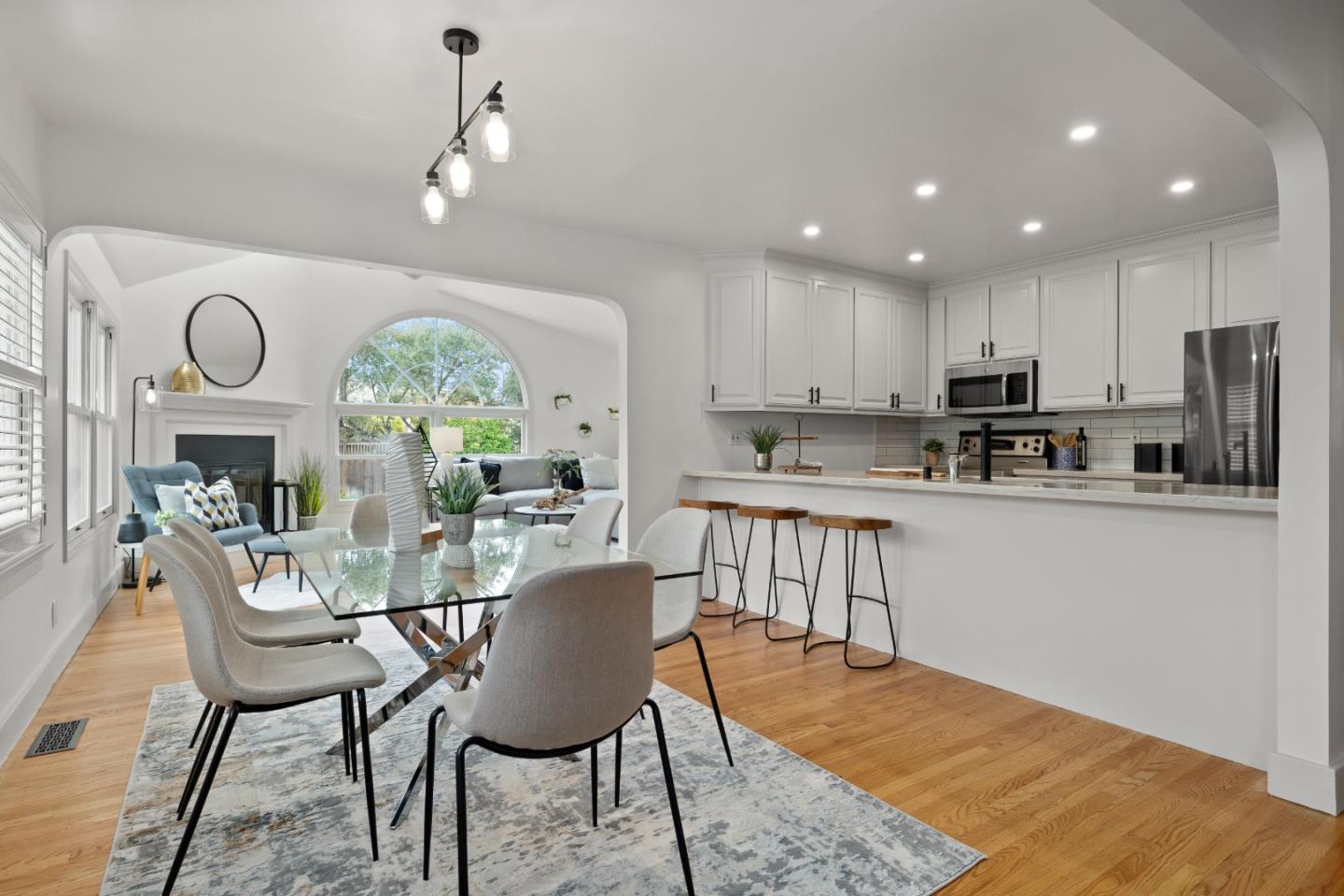 220 Channing Road Burlingame, CA 94010 - Photo 8 of 60 a kitchen with stainless steel appliances granite countertop a stove a refrigerator a kitchen island a dining table and chairs with wooden floor