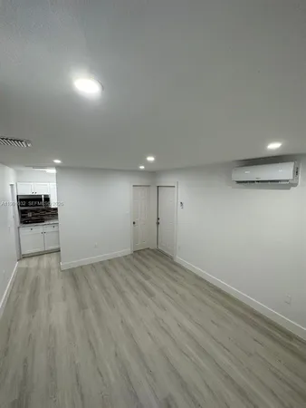 an empty room with wooden floor wooden cabinet and windows