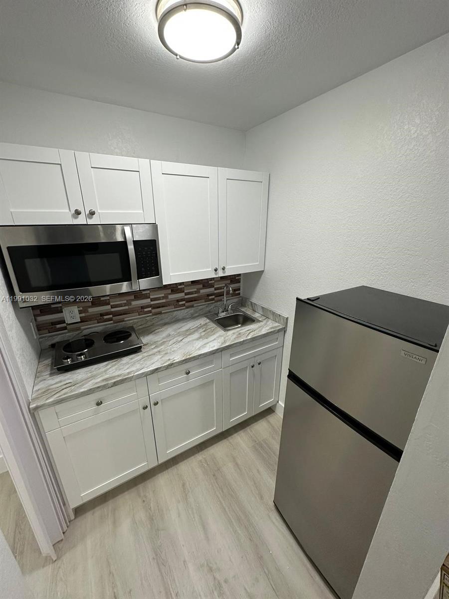 20926 Southwest 124th Ave Road Miami, FL 33177 - Photo 10 of 10 a kitchen with a sink a microwave and cabinets