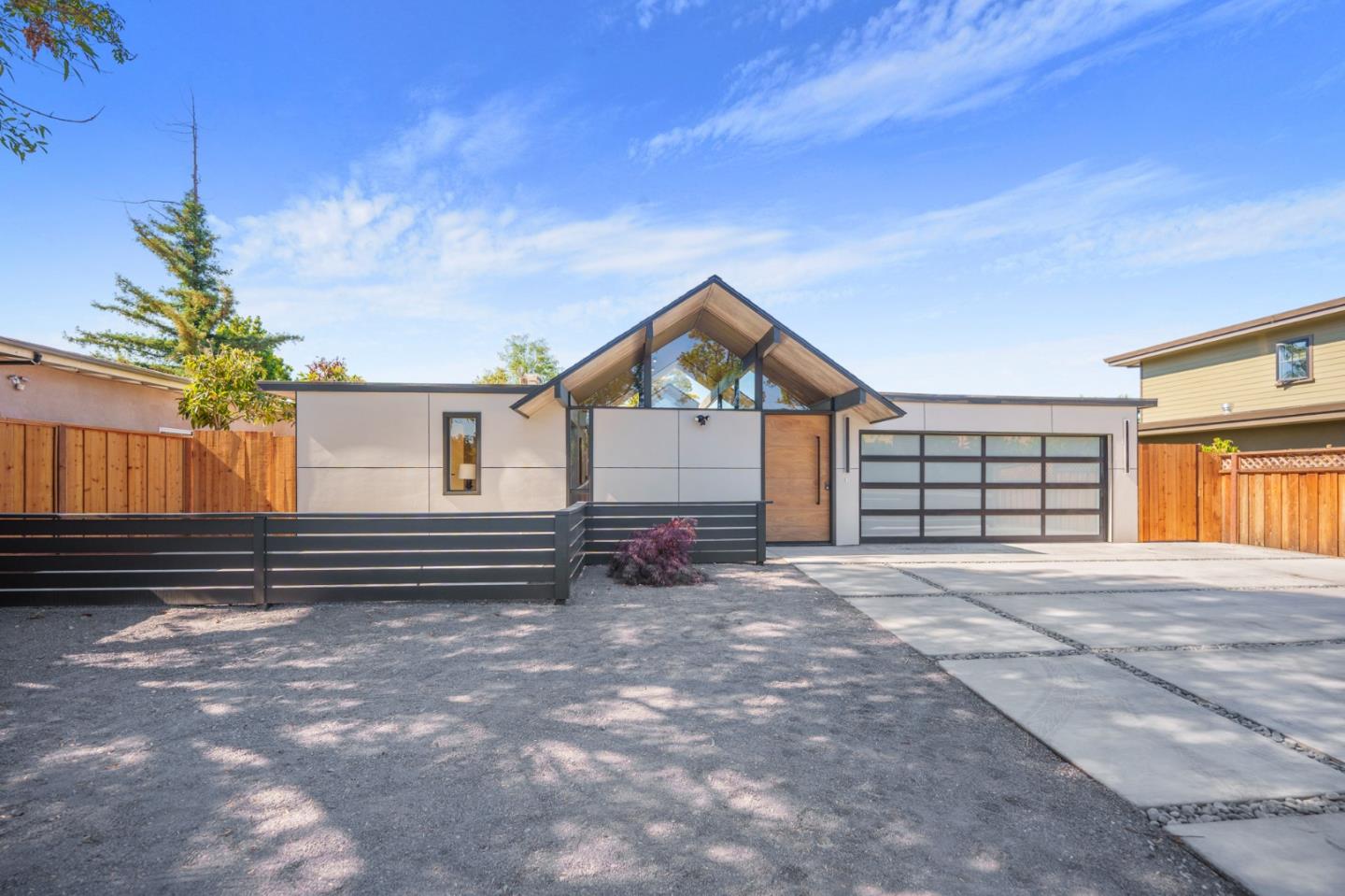 a view of a house with a yard and wooden fence