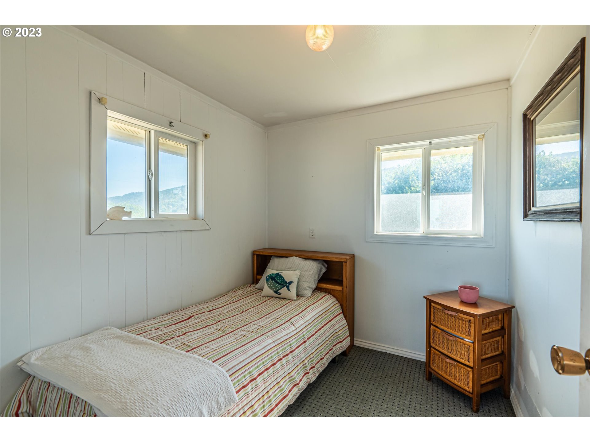 33032 Nesika Road Gold Beach, OR 97444 - Photo 11 of 35 a bedroom with a bed and a window
