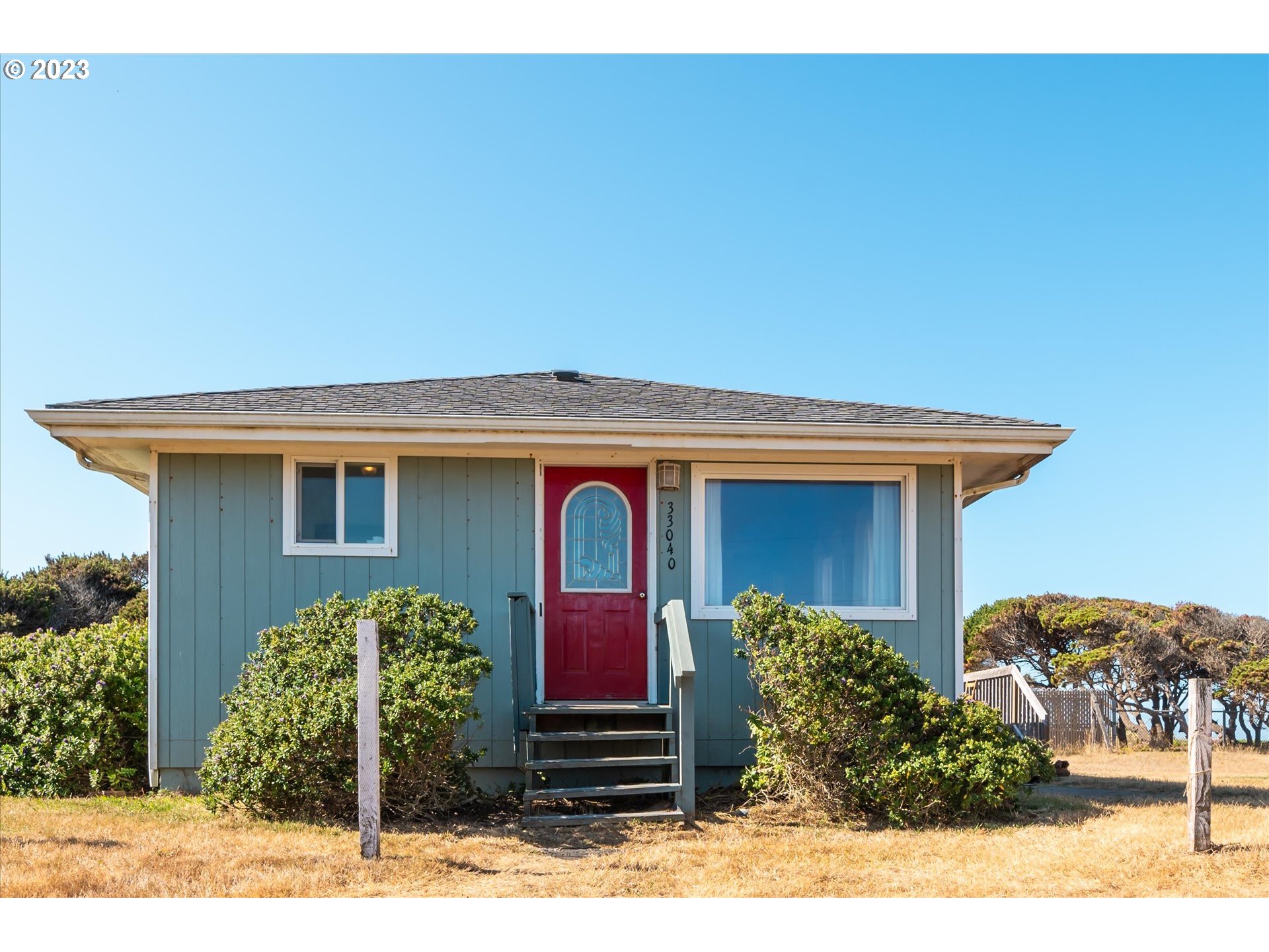33032 Nesika Road Gold Beach, OR 97444 - Photo 2 of 35 a front view of a house with garden