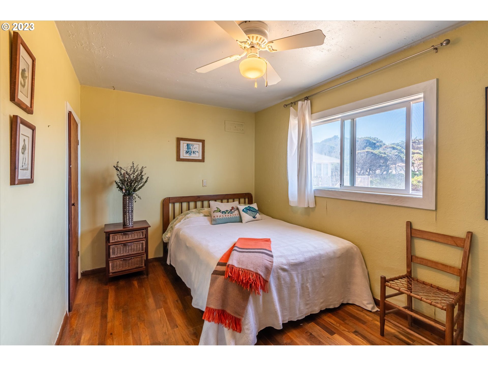 33032 Nesika Road Gold Beach, OR 97444 - Photo 23 of 35 a bedroom with a bed and a chandelier