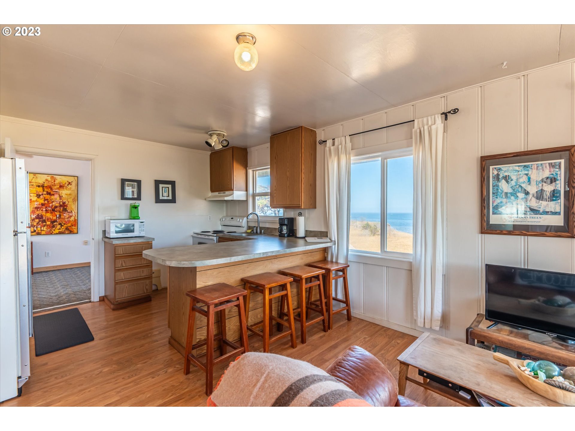 33032 Nesika Road Gold Beach, OR 97444 - Photo 5 of 35 a living room with stainless steel appliances furniture a rug and a kitchen view