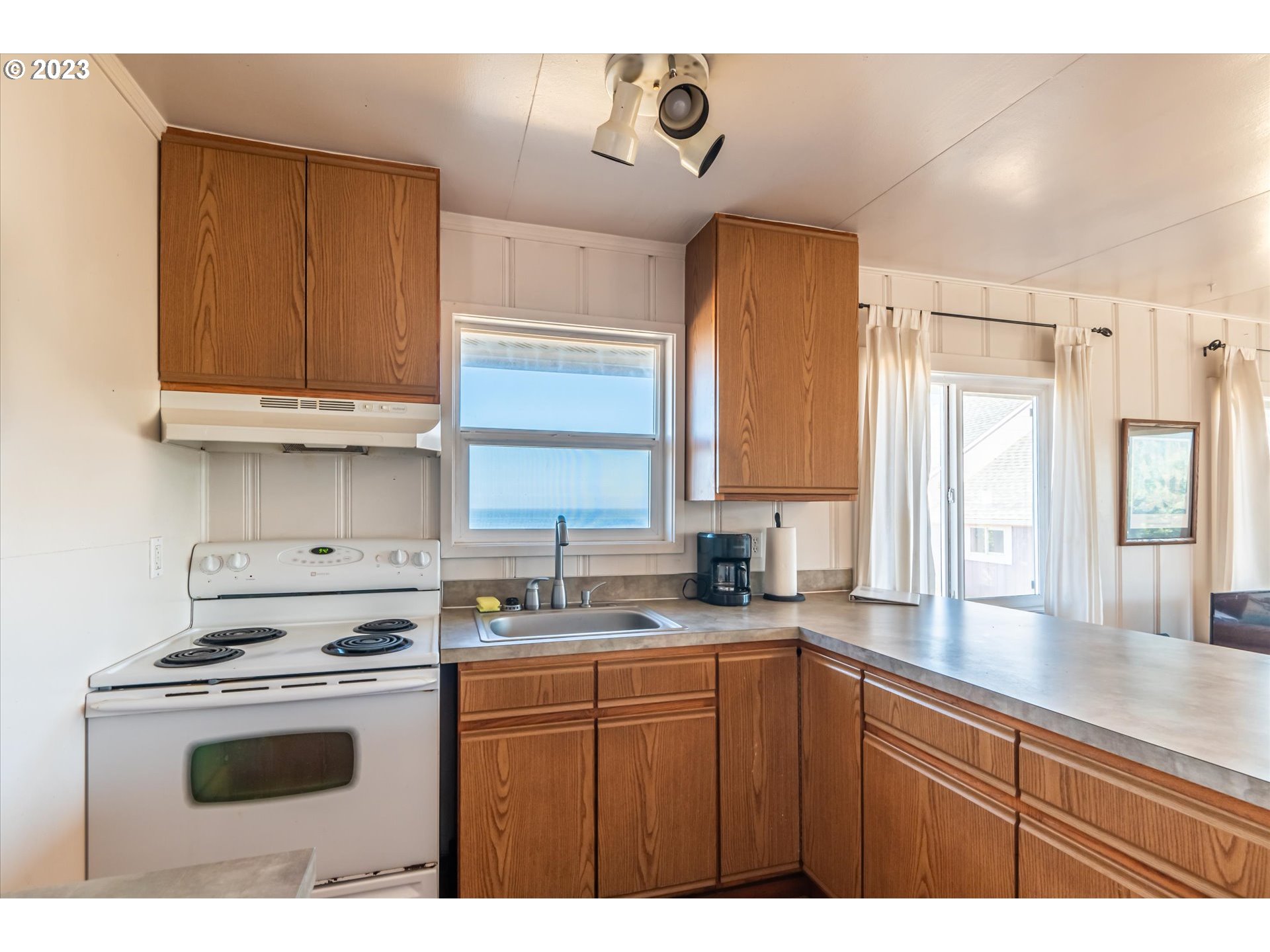 33032 Nesika Road Gold Beach, OR 97444 - Photo 8 of 35 a kitchen with kitchen island granite countertop a sink cabinets and stainless steel appliances