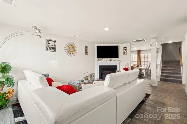 a living room with furniture a fireplace and a flat screen tv