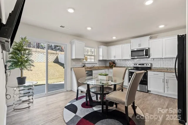 a kitchen with a dining table chairs and refrigerator