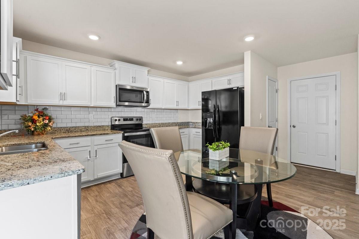 1317 Mifflin Lane Dallas, NC 28034 - Photo 8 of 19 a kitchen with stainless steel appliances granite countertop a stove a refrigerator a sink a dining table and chairs